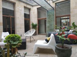 a patio with a couch and chairs and potted plants at Extérieur Chartrons Jardin Public Quais Quinconces XAVIER ARNOZAN in Bordeaux
