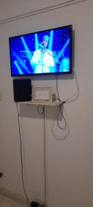 a flat screen tv on a stand with a keyboard at Santa clara 515 in Rio de Janeiro