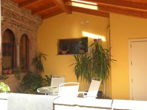 a living room with chairs and a tv on a wall at Hotel La Cascina in Fontanellato