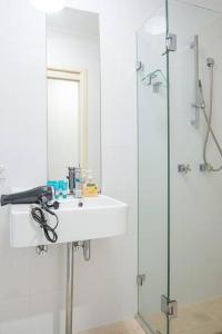 a bathroom with a sink and a glass shower at Charming house in Leichhardt in Sydney