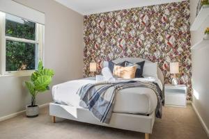 a bedroom with a bed and a floral wallpaper at Charming house in Leichhardt in Sydney