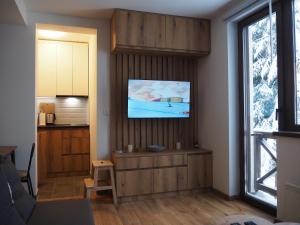 a living room with a flat screen tv on a wall at Apartman Duda in Kopaonik