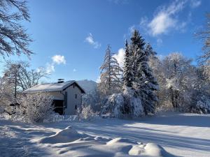 a house covered in snow next to a road at Ferienhaus Endrös - Chiemgau Karte in Inzell