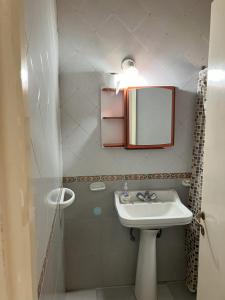 Baño pequeño con lavabo y espejo en Amplio depto para 4 personas a 1 cuadra del mar en Balneario Mar Chiquita