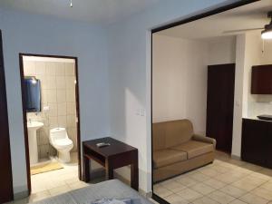 - une chambre avec un canapé et une salle de bains avec des toilettes dans l'établissement Apart otel Marina Loft 101, à Coco