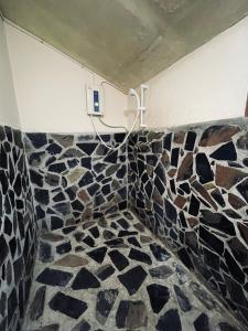 ein Bad mit Fliesenboden und einem Kreuz an der Wand in der Unterkunft Lungsonhouse in Pai