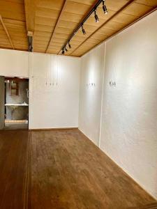 una stanza vuota con pareti bianche e soffitto in legno di ギャラリー宿　INNAHOUSE ANDAGALLERY a Murotsu