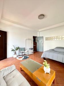 a bedroom with a bed and a couch and a table at After-Grad Poshtel in Pattaya South