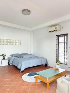 a bedroom with a bed and a coffee table at After-Grad Poshtel in Pattaya South