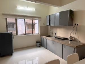 an empty kitchen with a counter and a window at Autumn: 1Bhk with Bathtub at Koregaon Park in Pune