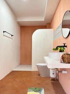 a bathroom with a sink and a toilet at After-Grad Poshtel in Pattaya South