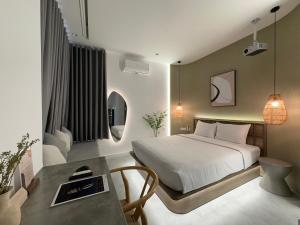 ホーチミン・シティにあるKIN WANDER - Tân Phongのベッドルーム1室(ベッド1台、テーブル付)