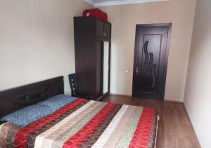 um quarto com uma cama, um armário e uma porta em GOAL ApartmentS 2 em Tbilisi