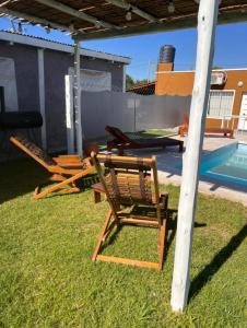 Villa Los Aromos的住宿－CÁBAÑAs , S,E,2，两把草坪椅和一张桌子,旁边是游泳池