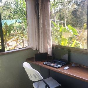 escritorio con ordenador portátil y silla frente a una ventana en Cabañita La Montaña de Las Brisas, en San Vito