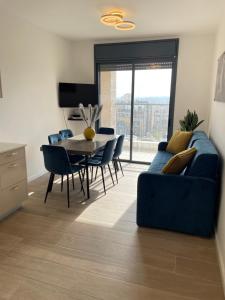 エルサレムにあるBeautiful 2BR near Mahane Yehudaの青いソファとテーブルのあるリビングルーム