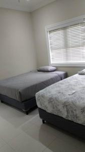 Duas camas num quarto branco com uma janela em Life of Montego Bay em Montego Bay