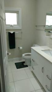 uma casa de banho branca com um WC e um lavatório em Life of Montego Bay em Montego Bay