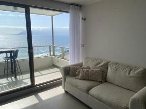 sala de estar con sofá y vistas al océano en Departamento Antofagasta. Playa privada, en La Chimba