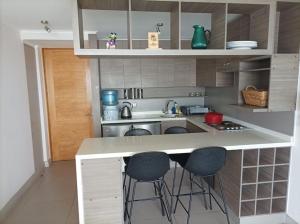 eine Küche mit einer Theke und Stühlen in der Unterkunft Departamento Antofagasta. Playa privada in La Chimba