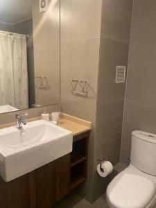 bagno con lavandino, servizi igienici e specchio di Departamento Antofagasta. Playa privada a La Chimba
