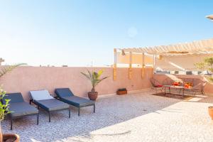 a patio with four blue chairs and a table at Villa Boutique Amani in Marrakesh