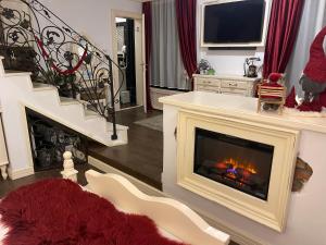 a living room with a fireplace and a staircase at Vila Cochet in Braşov