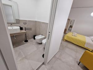 La salle de bains est pourvue d'un lavabo, de toilettes et d'un lit. dans l'établissement Neapolitan Skyscraper Suites, à Naples