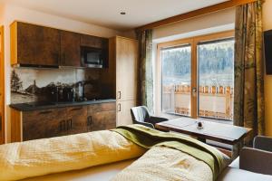 a bedroom with a bed and a table and a window at Apartments Haufhof , Haus im Ennstal bei Schladming in Haus im Ennstal