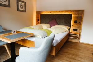 a bedroom with a bed and a table and chairs at Apartments Haufhof , Haus im Ennstal bei Schladming in Haus im Ennstal