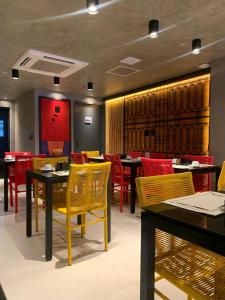 a restaurant with tables and chairs and red chairs at Place2You Hotel by Welkom in João Pessoa