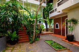 a courtyard of a building with trees and plants at La Veranda Di Serena in Unawatuna