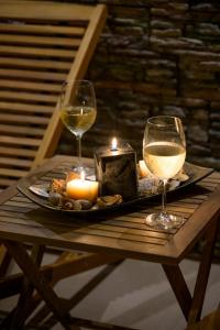 two glasses of wine and candles on a wooden table at Ахат- къща за гости in Kyustendil +4 photos