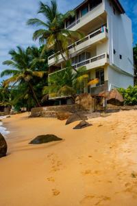 a building on the beach with footprints in the sand at La Veranda Di Serena in Unawatuna
