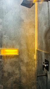 a bathroom with a yellow light on a wall at WorthMiles Resort in Manāli