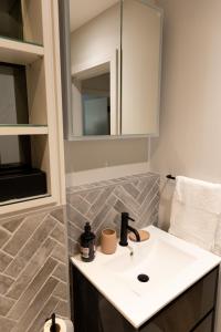 La salle de bains est pourvue d'un lavabo et d'un miroir. dans l'établissement Modern newly refurbished 2nd floor stylish flat in Fitzrovia, à Londres