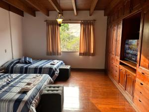a bedroom with two beds and a flat screen tv at Habitacion doble vista a la Huaca Miraflores in Lima