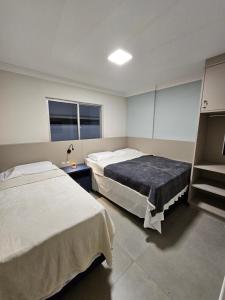 ein Krankenhauszimmer mit 2 Betten und einem Fenster in der Unterkunft Apartamento Quadra Mar ST Balneário Camboriú in Balneário Camboriú