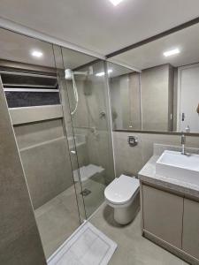 ein Bad mit einer Dusche, einem WC und einem Waschbecken in der Unterkunft Apartamento Quadra Mar ST Balneário Camboriú in Balneário Camboriú
