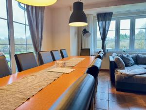 a dining room with a long table and a couch at Charmantes Ferienhaus an der Mosel in Ediger-Eller