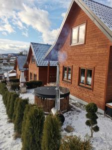 une maison avec un bain à remous dans la neige dans l'établissement Osada Zawóz, à Zawóz