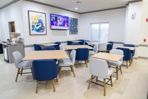 una sala de espera con mesas y sillas azules en Comfort Inn & Suites, en Schulenburg