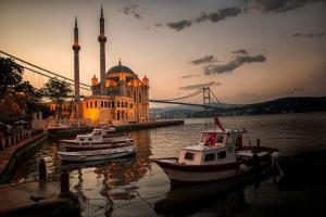 two boats in the water in front of a building with a bridge at istanbul vipinnhotels in Istanbul