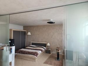 a bedroom with a bed and a glass wall at Grand Midia Resort, Sky level apartments in Aheloy