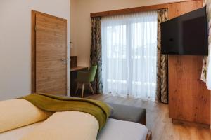 a bedroom with a bed and a flat screen tv at Apartments Haufhof , Haus im Ennstal bei Schladming in Haus im Ennstal