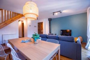 ein Wohnzimmer mit einem Tisch und einem blauen Sofa in der Unterkunft Las Vistas de Peña Blanca in Piedrafita de Jaca