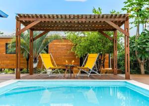 聖貝努瓦的住宿－Bungalow L'escale de Takamaka，一个带两把椅子和一张桌子的庭院,毗邻一个游泳池
