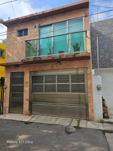 a building with two garage doors and a balcony at CONFORT in Veracruz
