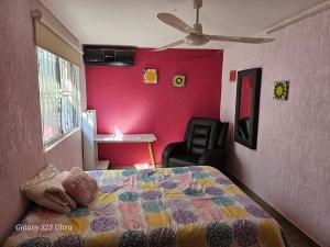 1 dormitorio con cama y pared de color rosa en CONFORT, en Veracruz