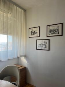 a bedroom with a chair and two pictures on the wall at Genex 37 in Novi Beograd